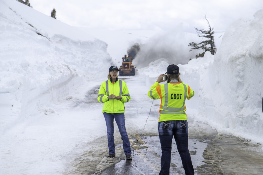 Capturing the essence of communication strategy at its peak! Join the best strategist in Aspen as they engage in conversation with a videographer atop Independence Pass, surrounded by the breathtaking spectacle of a CDOT snowplow clearing the snowy highway pass. Experience the convergence of strategy, communication, and mountain majesty in this captivating photo moment.